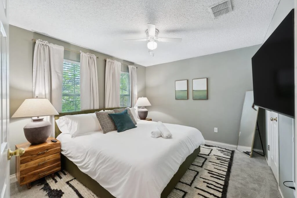 Contemporary urban Airbnb bedroom with gray walls, green accents, and mirrored doors