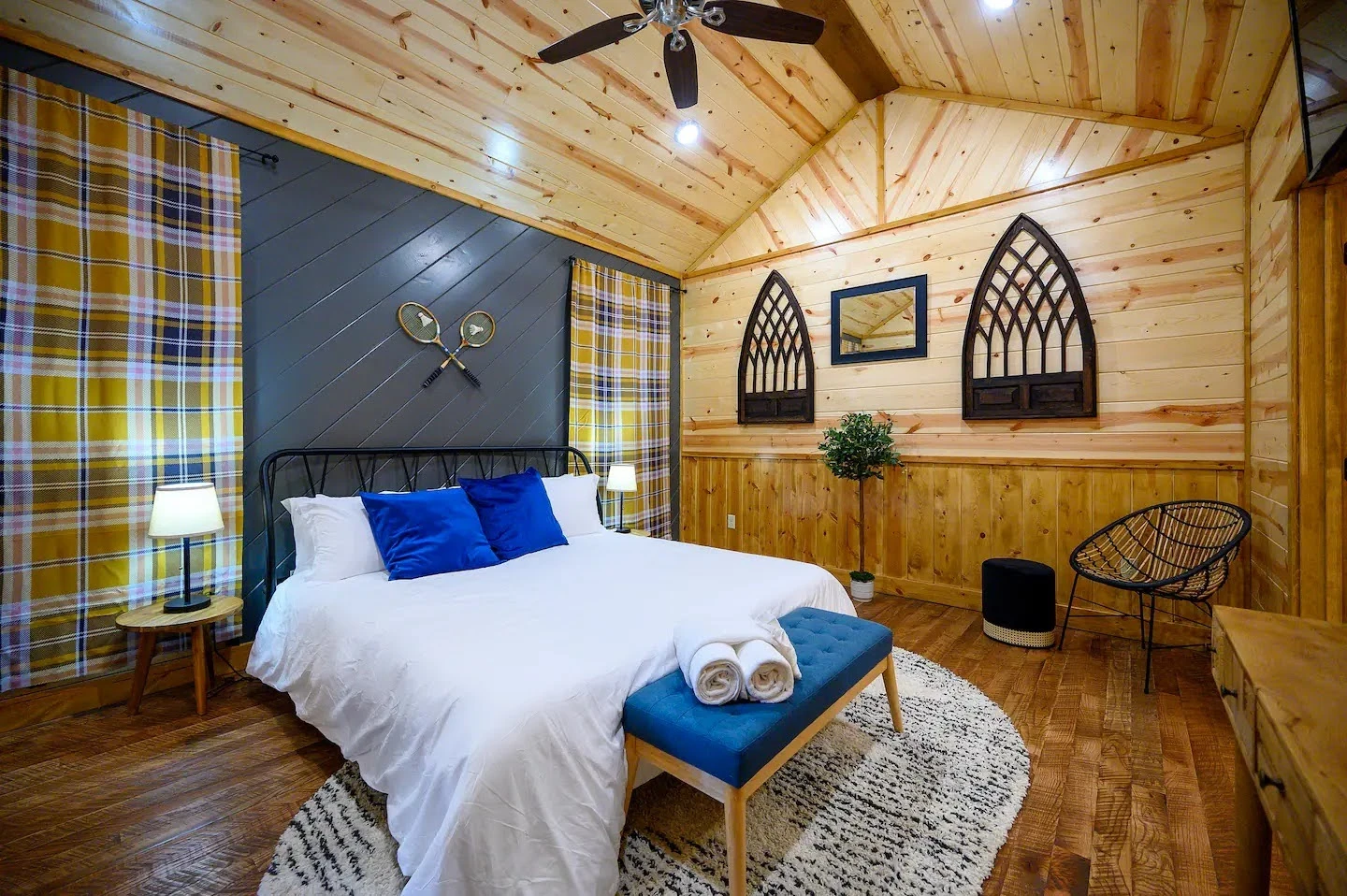 Loft Airbnb bedroom with sports equipment decor, plaid wallpaper, and a blue bench