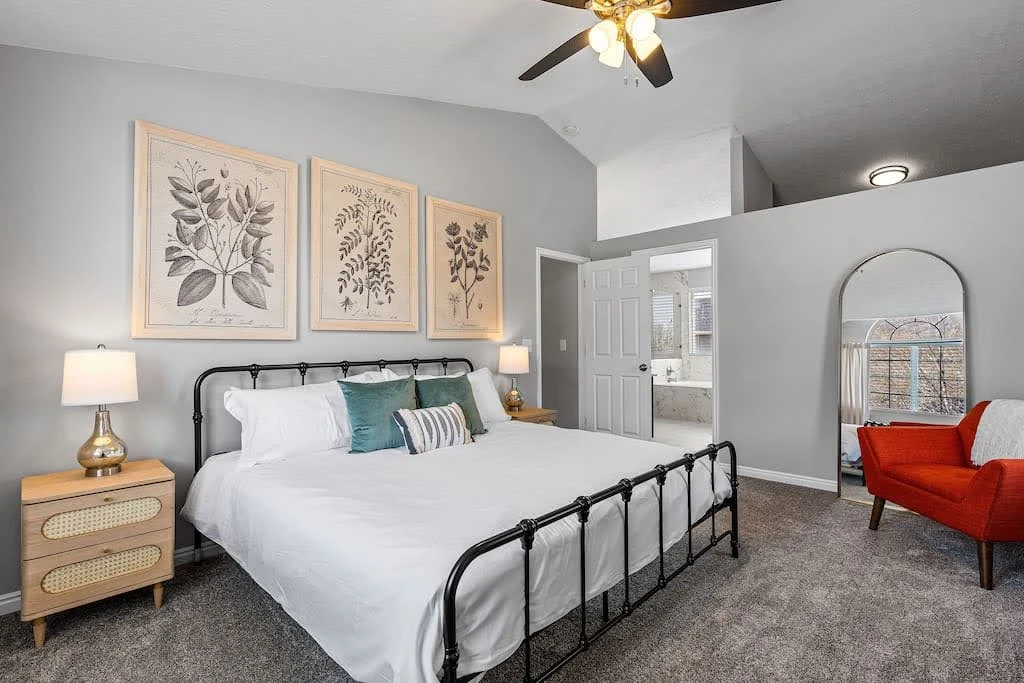 Scandinavian-style Airbnb bedroom with a black metal bed and light wood furniture